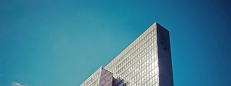 Torre de hotel envidraçada recortada contra o céu limpo.