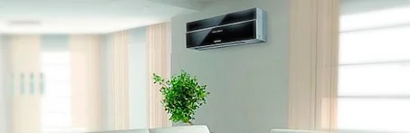 Sala de estar clara com um split instalado na parede acima do sofá.